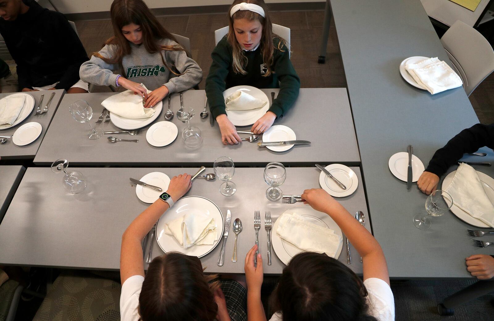 Students position their dishes and silverware in their proper places during an etiquette class at Blessed Sacrament School on Monday April 17, 2023.