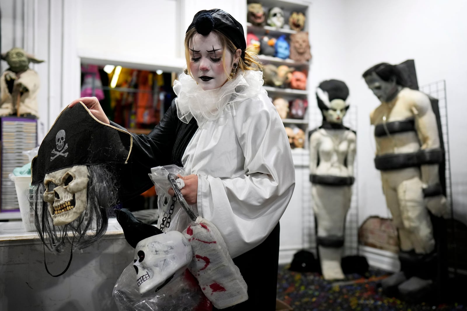 Olive Luther prepares to stock costume displays at The Theatrical Shop, Tuesday, Oct. 29, 2024, in West Des Moines, Iowa. (AP Photo/Charlie Neibergall)