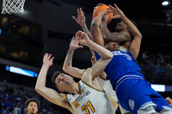 Missouri guard Caleb Grill (31) and Missouri guard Tony Perkins, back, battle Drake forward Cam Manyawu (3) for a rebound during the first half of the first round of the NCAA college basketball tournament, Thursday, March 20, 2025, in Wichita, Kan. (AP Photo/Charlie Riedel)