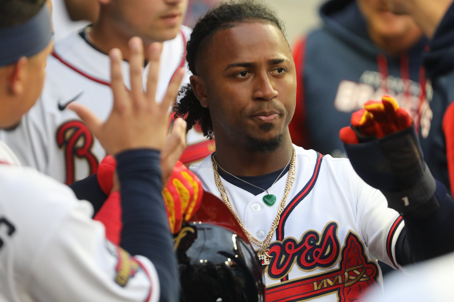 Braves second baseman Ozzie Albies gets high-fives in the dugout after scoring the first run against the Nationals on Monday night at Truist Park. (Miguel Martinez/miguel.martinezjimenez@ajc.com)