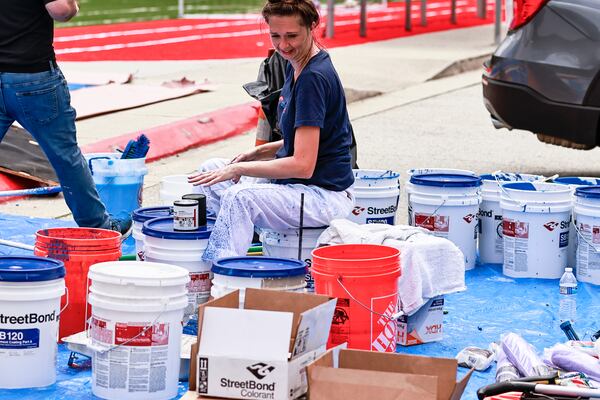 Amber Perez, a customer success rep with Streetbond prepares to mix paint for the SAE School basketball court on Thursday, August 25, 2022. (Natrice Miller/ Natrice.miller@ajc.com)