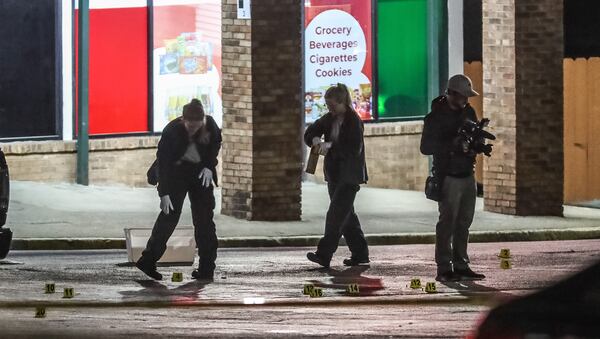 Gwinnett County investigators collect evidence in the parking lot of the Indian Trail Court shopping plaza, where a man was killed Wednesday morning.