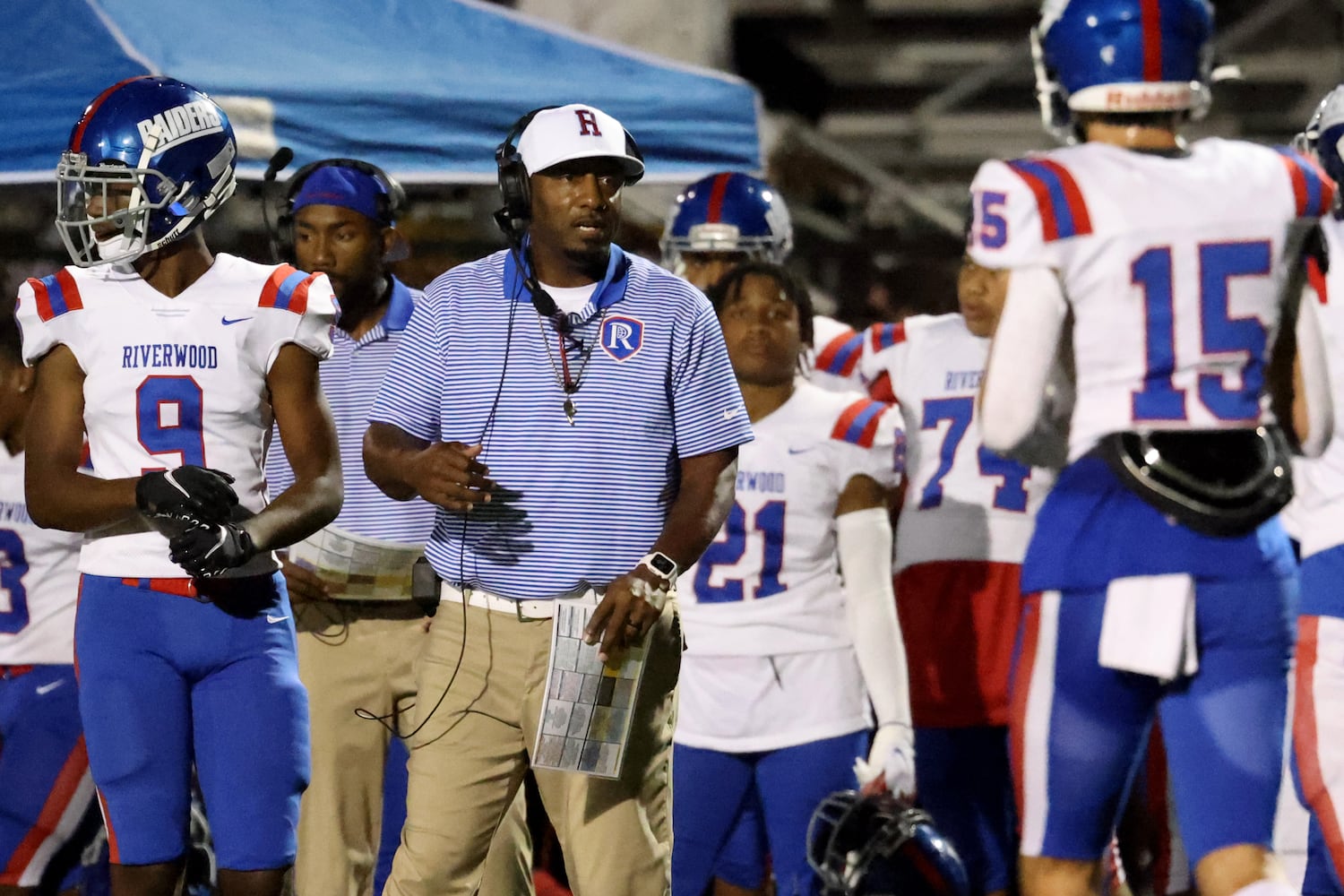 Sept. 24, 2021 - Johns Creek, Ga: Riverwood head coach Robert Edwards, center, talks with tight end Levi Linowes (15) during their game against Johns Creek at Johns Creek high school Friday, September 24, 2021 in Johns Creek, Ga.. JASON GETZ FOR THE ATLANTA JOURNAL-CONSTITUTION