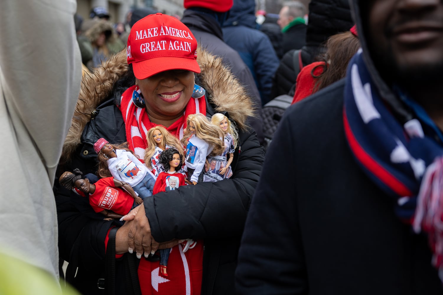 Tabatha Foster of New York holds Barbies with Trump-themed clothes while waiting to enter a Trump rally at Capital One Arena in Washington, D.C. on Sunday, January 19, 2025, one day before Donald Trump’s inauguration. (Arvin Temkar / AJC)