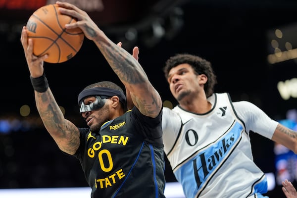 Golden State Warriors guard Gary Payton II (0) grabs a rebound from Atlanta Hawks forward Dominick Barlow (0) during the first half of an NBA basketball game, Saturday, March 22, 2025, in Atlanta. (AP Photo/Mike Stewart)