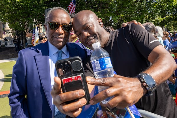 DeKalb CEO Michael Thurmond (Left)  poses for a picture with a crowd member before the statue unveiling ceremony honoring the late Congressman John Lewis in Decatur on Saturday, Aug 24, 2024.