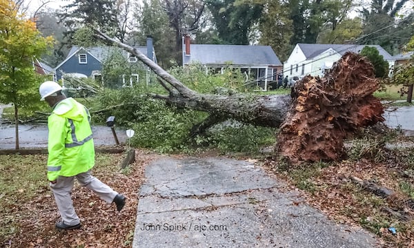 Chris Peart works to restore Comcast service after a downed tree knocked out power and internet lines on Westwood Avenue in southwest Atlanta. JOHN SPINK / JSPINK@AJC.COM