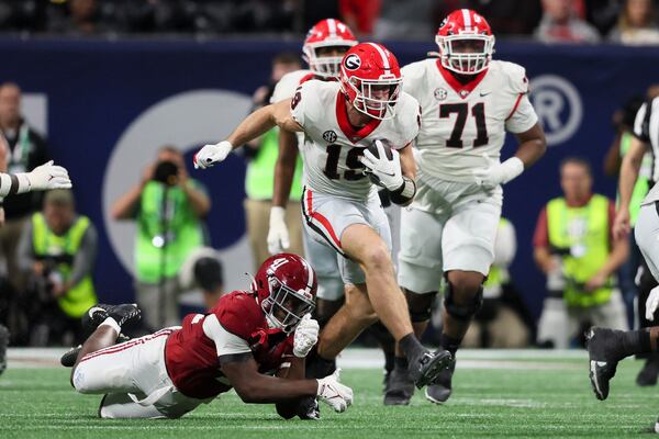 Georgia tight end Brock Bowers (19) runs after a catch against Alabama linebacker Chris Braswell (41) during the fourth quarter in the SEC Championship game at Mercedes-Benz Stadium, Saturday, December. 2, 2023, in Atlanta. Alabama won 27-24. (Jason Getz / Jason.Getz@ajc.com)