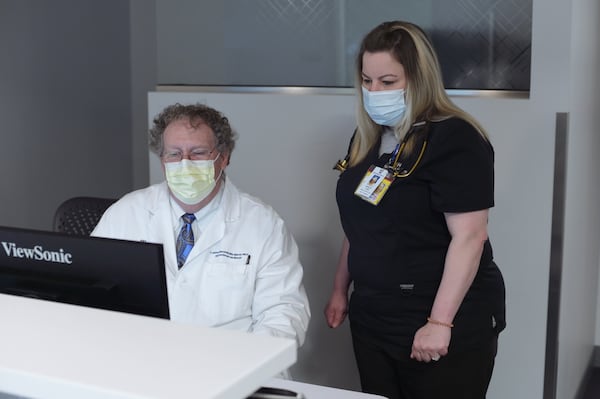 Dr. Jeffrey Marshall, chief of Northside Hospital Cardiovascular Institute and Ashley Morris, a medical assistant and practice coordinator, NCVI on April 18, 2022. Morris suffers from a racing heart beat and other health issues after getting COVID-19 in October.  (Natrice Miller / natrice.miller@ajc.com)