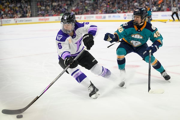 Minnesota forward Katy Knoll keeps the puck away from New York forward Noora Tulus during the second period of a PWHL game between the New York Sirens and the Minnesota Frost, at Little Caesars Arena, in Detroit, Sunday, March 16, 2025. (David Guralnick/Detroit News via AP)