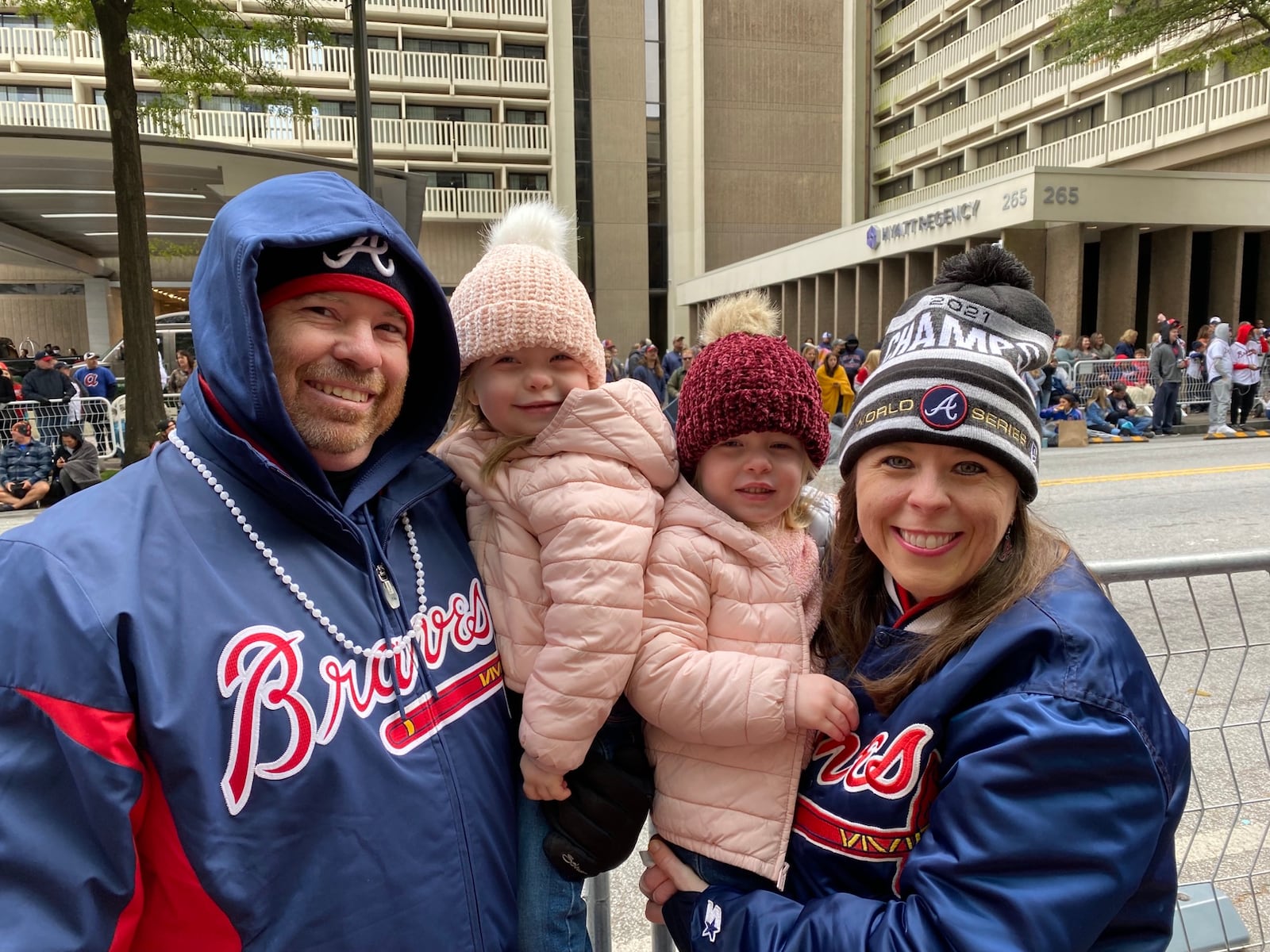 Jason and Heather Kirksey of Marietta with their three-year-old twins Harper, left, and Emma Cate celebrate the World Series win on Peachtree Street. VANESSA McCRAY/ AJC