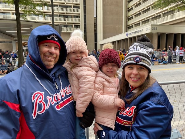 Jason and Heather Kirksey of Marietta with their three-year-old twins Harper, left, and Emma Cate celebrate the World Series win on Peachtree Street. VANESSA McCRAY/ AJC