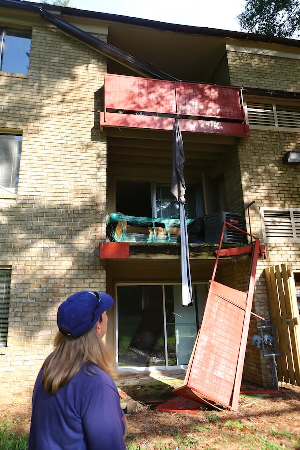 Kristy Neff walks behind her apartment building where porches and gutters are collapsing and windows shattered awaiting repair in The Village at Kensington on Sept. 6, 2022, in Decatur.   “Curtis Compton / Curtis Compton@ajc.com