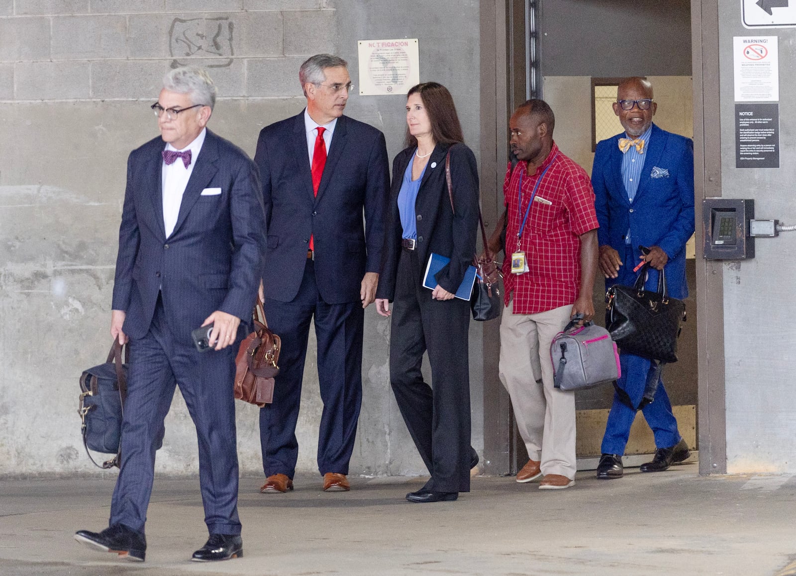 Georgia Secretary of State Brad Raffensperger (second from left) leaves Federal Court in Atlanta after testifying on Monday, Aug. 28, 2023.  (Miguel Martinez / Miguel.Martinezjimenez@ajc.com)