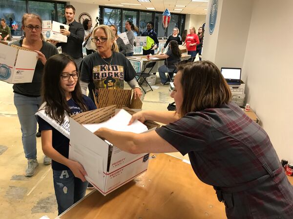  Volunteer Monica Ricci (right) placing letters in a box for another volunteer. CREDIT: Rodney Ho/rho@ajc.com