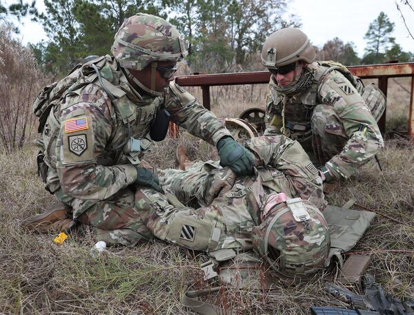 Sgt. Quantez Harper, left, and Pfc. Josh Radermacher aid Pvt. Shaun Rodecker, who was pretending to be gravely injured by an improvised explosive device during a training event at Fort Stewart. They are part of the Georgia National Guard’s 48th Brigade, which is deploying next month to Afghanistan. Curtis Compton/ccompton@ajc.com