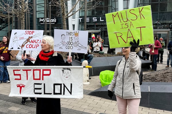 FILE - Protesters rally outside of a Tesla store in Boston, Saturday, March 1, 2025, against the company's CEO, Elon Musk, who is leading an effort to cut government jobs on behalf of President Donald Trump. (AP Photo/Rodrique Ngowi, File)