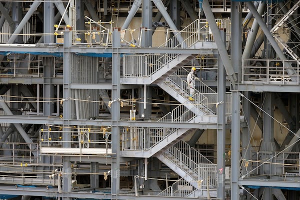 A worker in hazmat suits take stairs at the damaged Unit 1 reactor of the Fukushima Daiichi nuclear power plant, operated by Tokyo Electric Power Company Holdings (TEPCO), in Okuma town, northeastern Japan on Monday Feb. 20, 2025. (AP Photo/Eugene Hoshiko)