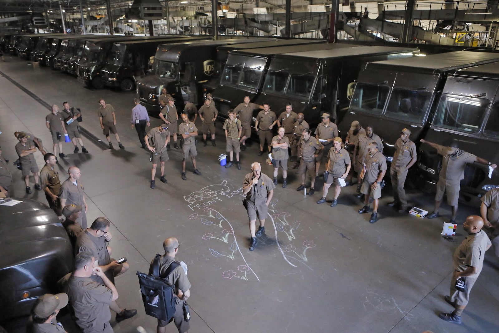 Drivers get in a little stretching and safety advice during a morning huddle at the UPS sorting facility in Roswell. BOB ANDRES /BANDRES@AJC.COM