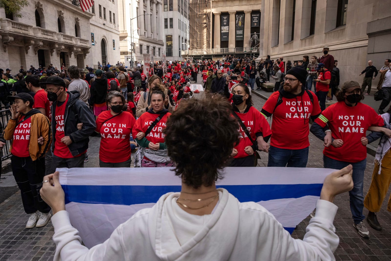 A pro-Israel protester holds an Israeli flag as demonstrators protest Israel's war against Hamas outside the New York Stock Exchange, Monday, Oct. 14, 2024, in New York. (AP Photo/Yuki Iwamura)