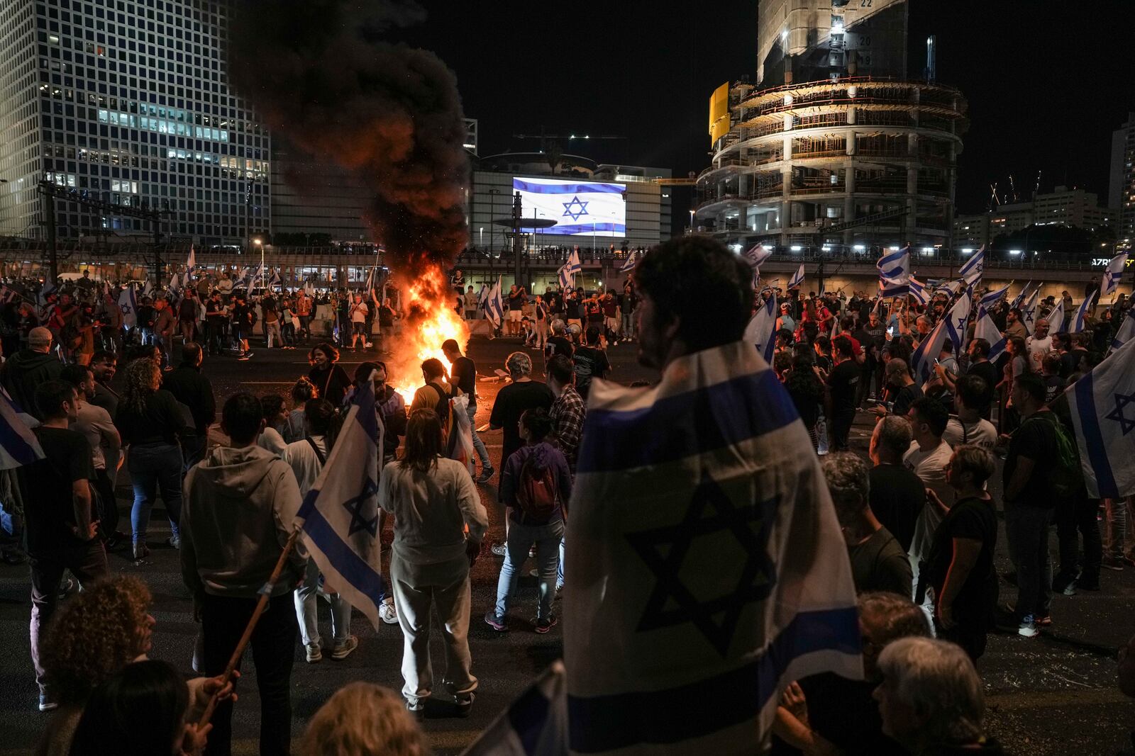 Israelis light a bonfire during a protest after Prime Minister Benjamin Netanyahu has dismissed his popular defense minister Yoav Gallant, in Tel Aviv, Israel, Tuesday, Nov. 5, 2024. (AP Photo/Oded Balilty)