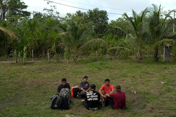 Venezuelan migrants sit in Puerto Carti, on Panama's Caribbean coast, Saturday, Feb. 22, 2025, where they plan to board boats to Colombia after turning back from southern Mexico where they gave up hopes of reaching the U.S. amid President Trump's crackdown on migration. (AP Photo/Matias Delacroix)