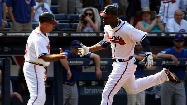 Brave rookie Jason Heyward is congratulated by third-base coach Brian Snitker while rounding bases during his first inning, three-run homer.