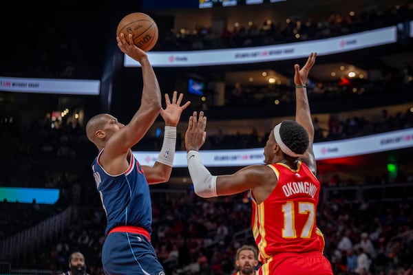 Los Angeles Clippers guard Kris Dunn (8), left, makes a basket against Atlanta Hawks forward Onyeka Okongwu (17), right, during the first half of an NBA basketball game, Friday, March 14, 2025, in Atlanta. (AP Photo/Erik Rank)