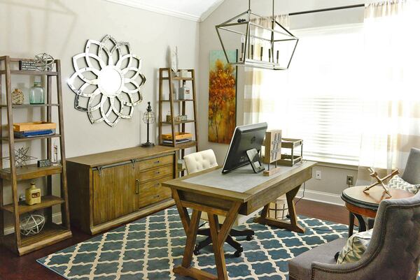 A wood desk, credenza and bookcase from Underpriced Furniture give the home office a warm, modern feel. The metal wall art and trellis design on the rug bring pattern add pattern and visual interest.