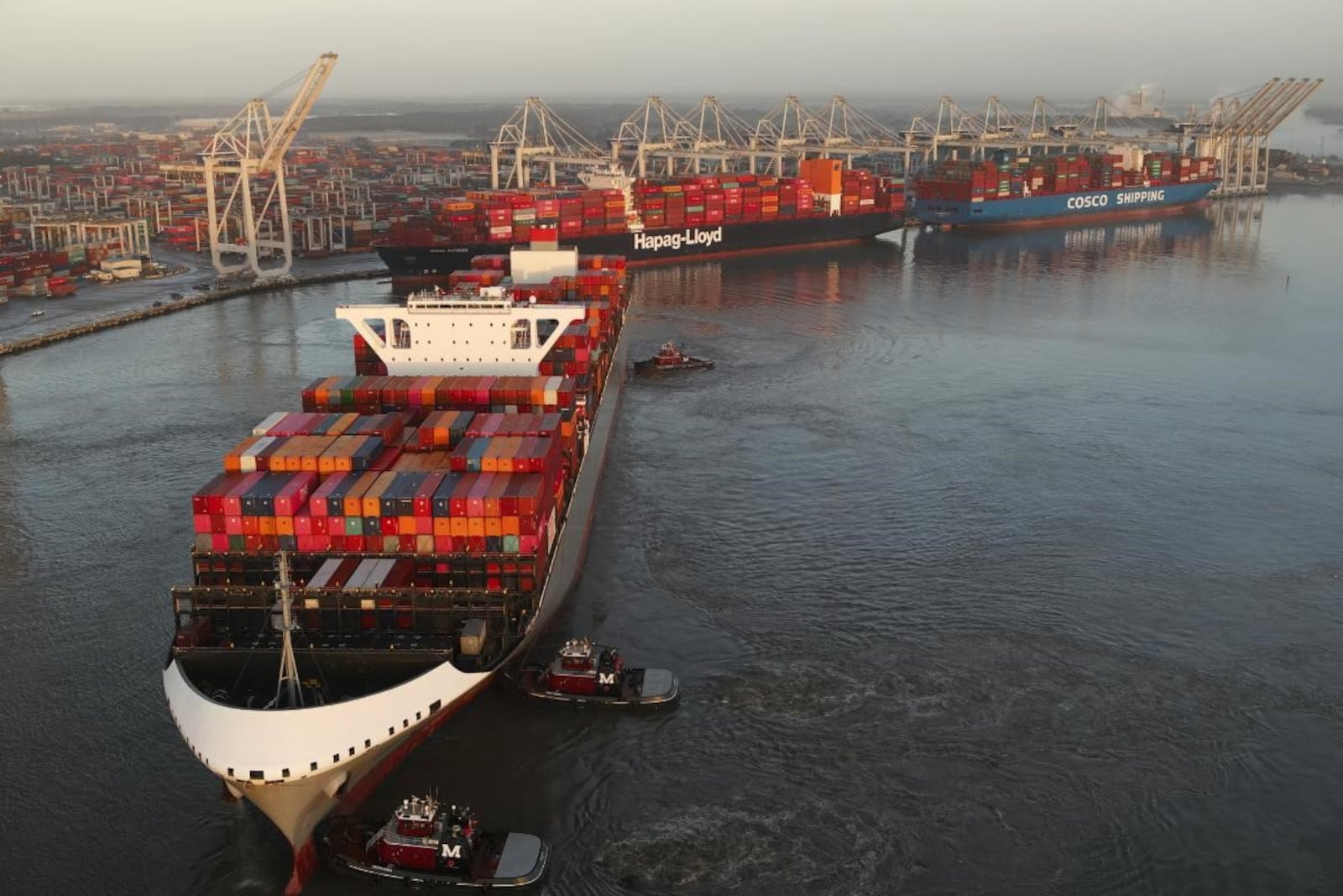 Tugboats push a cargo ship into position at the Port of Savannah. A river pilot boards each freighter at the start of the shipping channel and guides it to the docks. (Georgia Ports Authority)