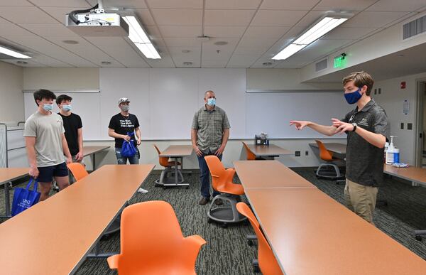 Tour guide John Hovell (right) speaks to potential students and a parent (from left) Josh Thompson, 17,  Ben Thompson (twin brother), 17, Logan Hart, 20, and Robert Thompson (father of the twin brothers) during a tour of the University of North Georgia's Dahlonega campus on Wednesday, April 28, 2021. (Hyosub Shin / Hyosub.Shin@ajc.com)