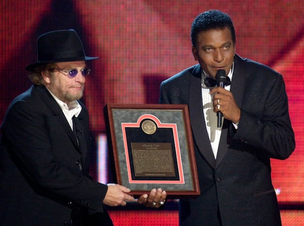 Charley Pride, right, receives his Country Music Hall of Fame plaque from Merle Haggard at the Country Music Association Awards show at the Grand Ole Opry House in Nashville, Tennessee, on October 4, 2000. (AP Photo/Charlie Neibergall, File)