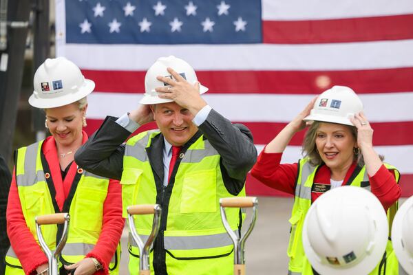 Brookhaven Mayor John Ernst, center, and City Councilwomen Madeleine Simmons, left, and Linley Jones put on hard hats before performing a groundbreaking ceremony for Brookhaven’s $78 million City Hall at the Brookhaven MARTA Station parking lot, Wednesday, October 11, 2023, in Atlanta. (Jason Getz / Jason.Getz@ajc.com)