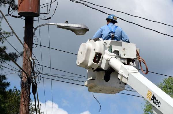 Contractors for Georgia Power, replace streetlights in Dunwoody in May. Across the nation, cities are installing energy-saving, low-maintenance LED street lamps that promise to cut their light bills by 50-70 percent. KENT D. JOHNSON /kdjohnson@ajc.com