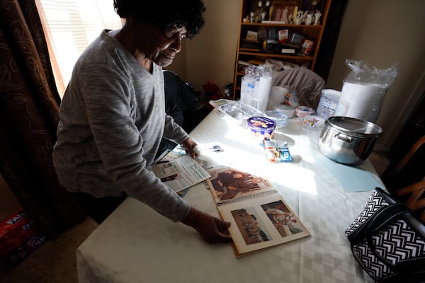 Sally Mae Hollis displays a scrapbook she created with photographs of President Jimmy Carter and his wife, Rosalynn, taken during their visit to help build her back deck in 1988 as part of his work project with Habitat for Humanity, on Thursday, Jan. 2, 2025. (Miguel Martinez/AJC)