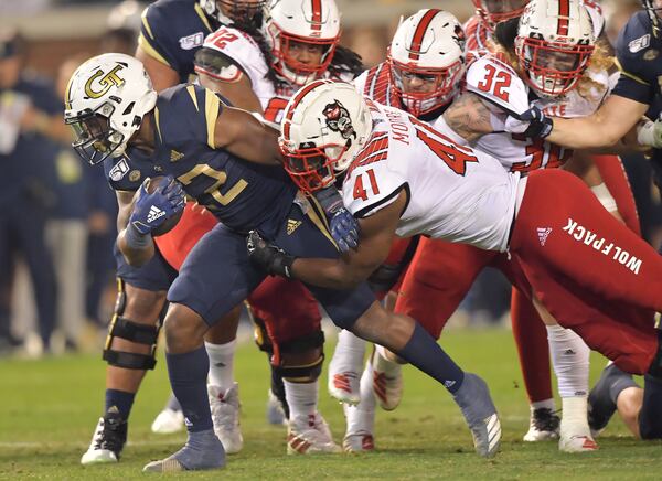 Georgia Tech running back Jamious Griffin (22) gets tackled from behind by North Carolina State linebacker Isaiah Moore (41) Thursday, Nov. 21, 2019, at Bobby Dodd Stadium in Atlanta.