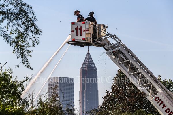 Firefighters douse hot spots Friday morning after a blaze at a warehouse on Bishop Street.