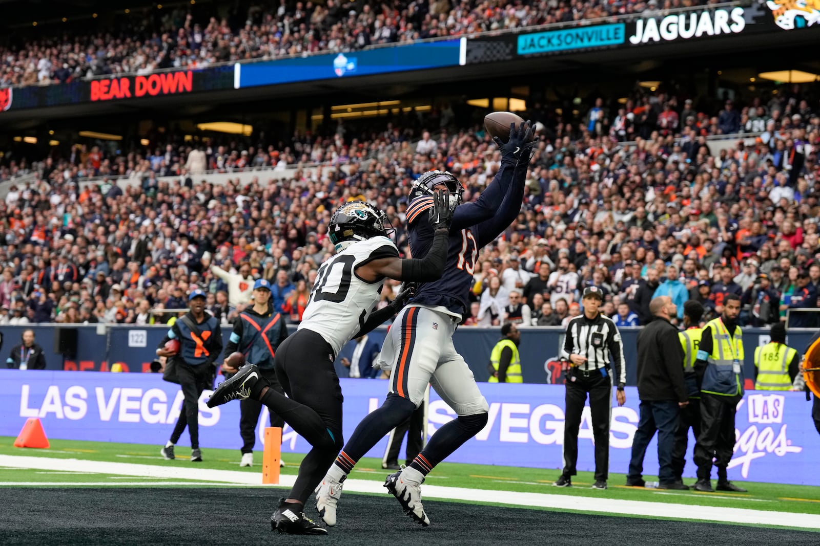 Chicago Bears wide receiver Keenan Allen (13), right, catches the ball to score a touchdown during the fourth quarter of an NFL football game at the Tottenham Hotspur stadium between the Jacksonville Jaguars and Chicago Bears in London, Sunday, Oct. 13, 2024. (AP Photo/Steve Luciano)