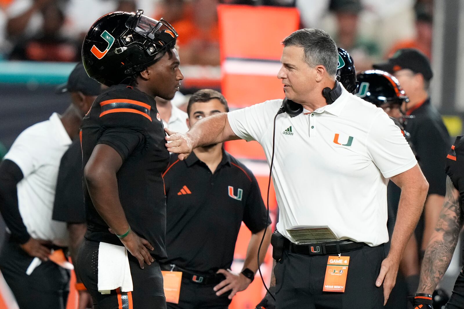 Miami head coach Mario Cristobal, right, talks with quarterback Cam Ward, left, during the first half of an NCAA college football game against Florida State, Saturday, Oct. 26, 2024, in Miami Gardens, Fla. (AP Photo/Lynne Sladky)