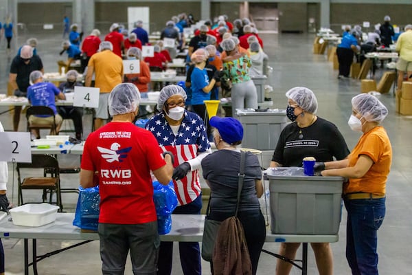 Volunteers filled bags of oatmeal that will eventually be part of the 200,000 meals for the Atlanta Community Food Bank during the 9/11 National Day of Service at the Georgia World Congress Center on Saturday, September 11, 2021.  STEVE SCHAEFER FOR THE ATLANTA JOURNAL-CONSTITUTION