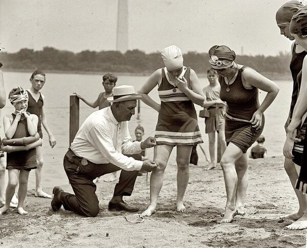 June 30, 1922 -- Washington policeman Bill Norton measuring the distance between knee and suit at the Tidal Basin bathing beach after Col. Sherrill, Superintendent of Public Buildings and Grounds, issued an order that suits not be over six inches above the knee. (Library of Congress)