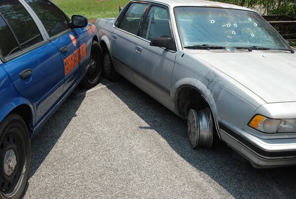 Crime scene photo shows the car driven by Caroline Small. Police fired eight bullets through her windshield as her vehicle was pinned and had no where to go.