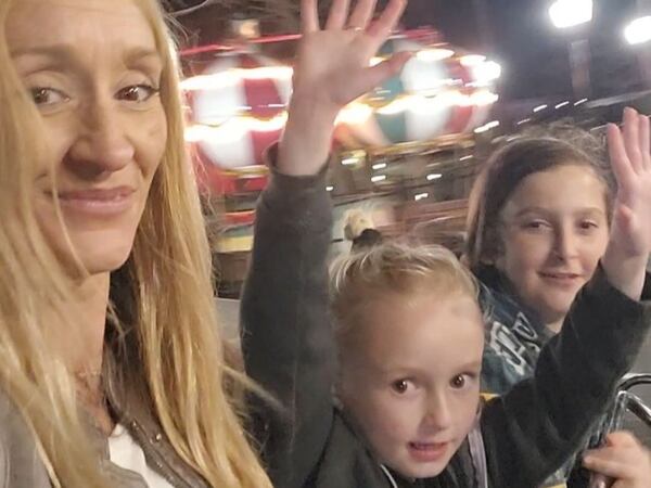 Jerica Johnson (left) and her children, Nevaeh, 6, and Nathan, 13, have fun on a ride at Six Flags Over Georgia prior to a shooting outside the park.