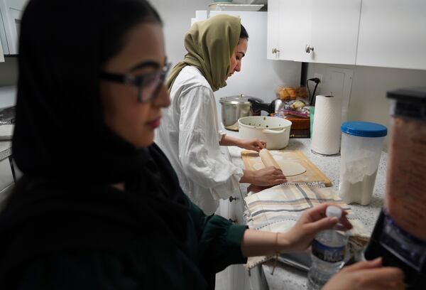 Marjila Badakhsh, left, and her roommate Maryam Rahimi cook together before breaking their daily fast during the Muslim holy month of Ramadan at their apartment in Alexandria, Va., Wednesday, March 5, 2025. (AP Photo/Jessie Wardarski)