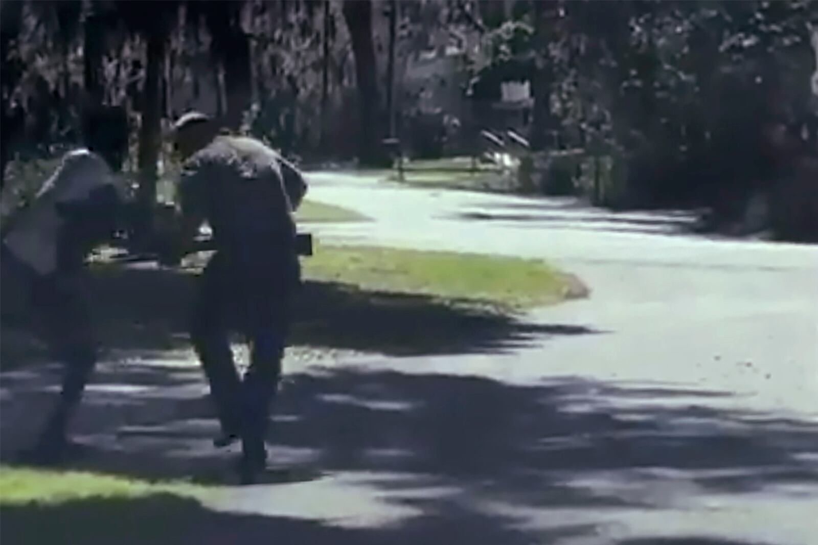 ADDS THAT THE AP HAS NOT BEEN ABLE TO VERIFY THE SOURCE OF THE VIDEO - This image from video posted on Twitter Tuesday, May 5, 2020, purports to show Ahmaud Arbery, left, struggling with Travis McMichael over a shotgun on a street in a neighborhood outside Brunswick, Ga., on Feb. 23, 2020. McMichael's father, Gregory, who was also at the scene, said Arbery was shot as the two men fought over the gun, according to the police report. The AP has not been able to verify the source of the video. (Twitter via AP)