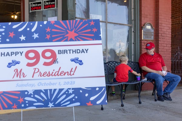 Mike Bennett and his son Reid, 6, eat ice cream in downtown Plains on Saturday, September 30, 2023, the day before Jimmy Carter’s 99th birthday. (Arvin Temkar/arvin.temkar@ajc.com)