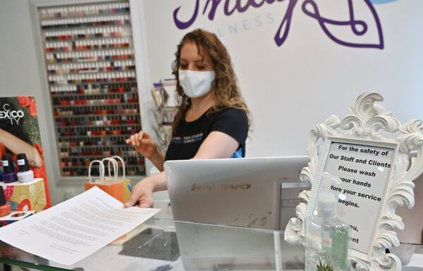 Paris Campeau, owner, printed out a waiver form before she serves a customer at Indigo Wellness Spa in Kirkwood on Wednesday, May 27, 2020. Paris Campeau didn’t open her wellness boutique when the governor said she could a month ago, but now, with bills piling up and some clients ready to come by, she’s giving it a shot. (Hyosub Shin / Hyosub.Shin@ajc.com)