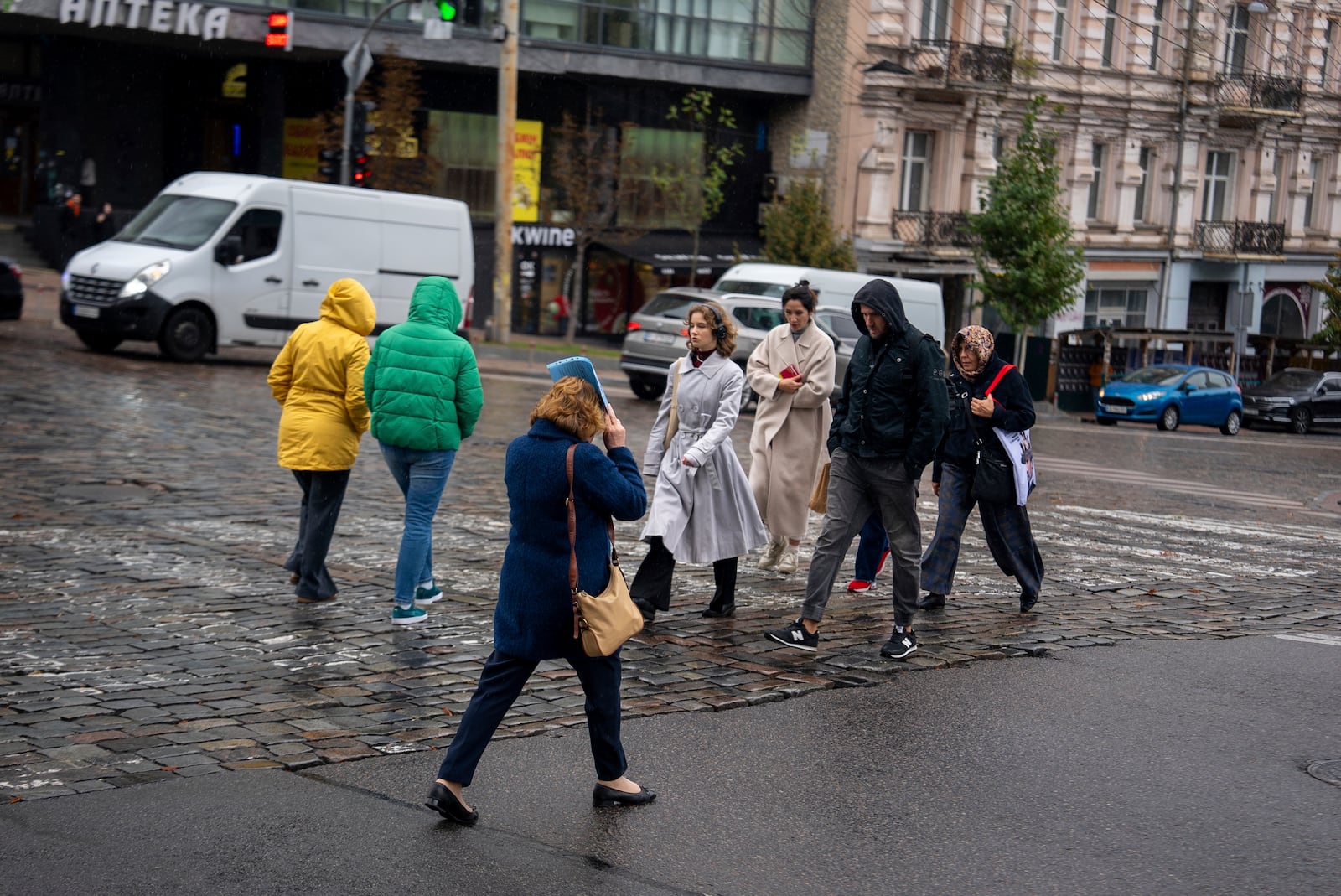 Locals cross a street during rain in Kyiv, Ukraine, Monday, Oct. 14, 2024.(AP Photo/Alex Babenko)