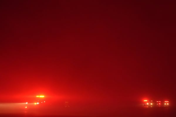 Fire trucks are parked along Pacific Coast Highway as smoke from the Franklin Fire fills the air in Malibu, Calif., Tuesday, Dec. 10, 2024. (AP Photo/Jae C. Hong)