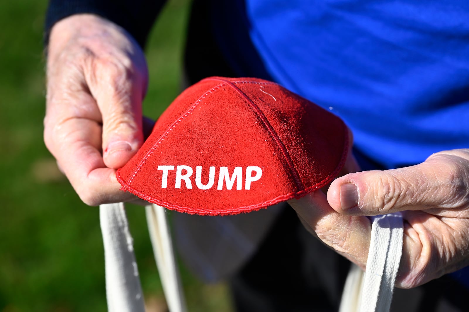 Republican Jewish Coalition member David Cuttner displays a yarmulke promoting Republican presidential nominee former President Donald Trump while canvassing a neighborhood, Sunday, Oct. 27, 2024, in West Bloomfield Township, Mich. (AP Photo/Jose Juarez)